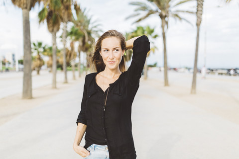 Lächelnde junge Frau an der Uferpromenade, lizenzfreies Stockfoto