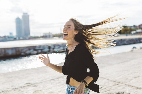 Exuberant young woman at the seafront - GIOF01827