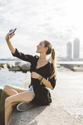 Junge Frau macht ein Selfie an der Strandpromenade - GIOF01833