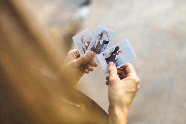 Junge Frau schaut sich Sofortfotos von sich selbst an - GIOF01844