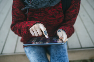 Close-up of tattooed woman's hands using tablet - KIJF01196