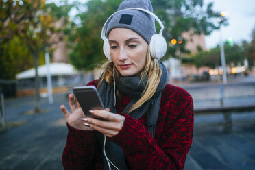 Junge Frau, die mit einem Smartphone Musik hört - KIJF01204