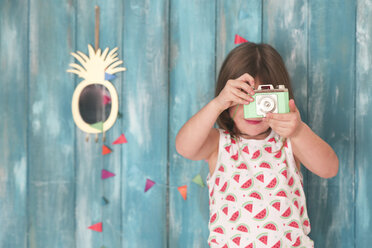 Porträt eines kleinen Mädchens, das mit einer alten Spielzeugkamera spielt - RTBF00654