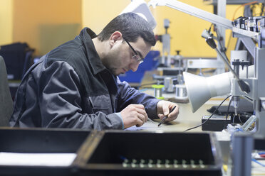 Mann bei der Arbeit in einer Sensorikanlage - SGF02109