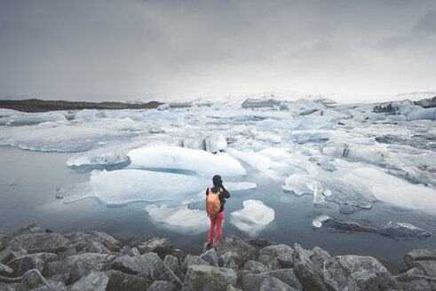 Iceland, view of Joekulsarlon, glacial river lagoon with man standing in the foreground - EPF00322