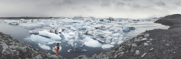 Iceland, panoramic view of Joekulsarlon, glacial river lagoon with man standing in the foreground - EPF00325