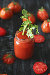 Glas Tomatensaft mit Staudensellerie auf schwarzem Holz - RTBF00660