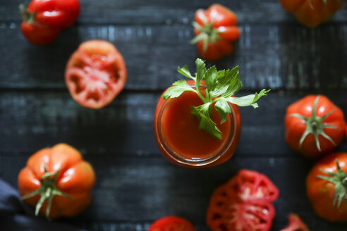 Glas Tomatensaft mit Staudensellerie auf schwarzem Holz - RTBF00661