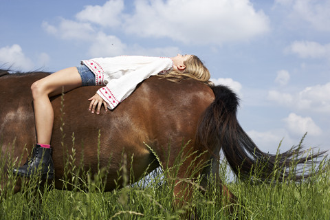 Mädchen auf dem Pferderücken liegend, lizenzfreies Stockfoto