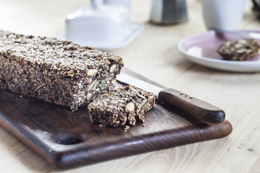 Home-baked wholemeal gluten-ree bread with nuts and seeds on wooden board - SBDF03152