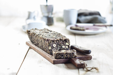 Home-baked wholemeal gluten-ree bread with nuts and seeds on wooden board - SBDF03154