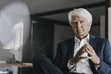Portrait of white haired senior businessman in his office - KNSF01016