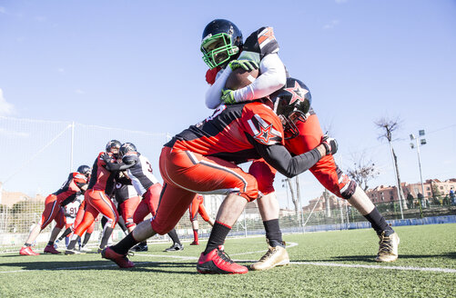 American football player being tackled by opponent player during a match - ABZF01902