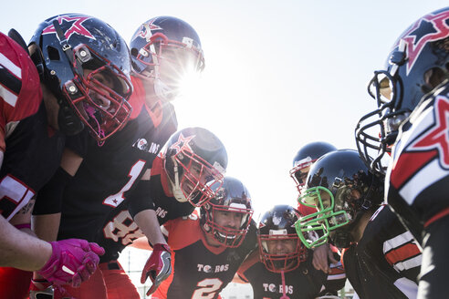 American football players talking and cheering in a circle before a game - ABZF01920