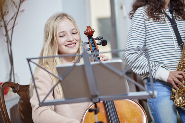 Zwei Mädchen spielen zusammen Cello und Saxophon - RHF01814
