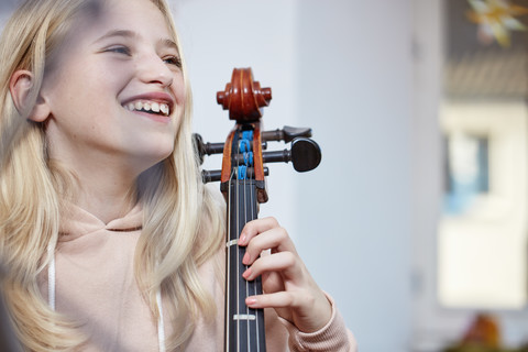 Porträt eines glücklichen Mädchens mit Cello, lizenzfreies Stockfoto