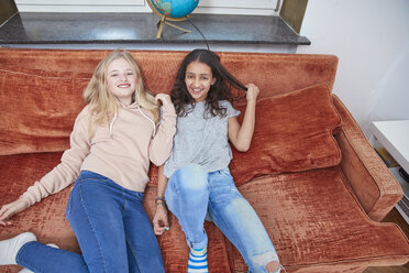 Two happy girls relaxing on couch - RHF01816