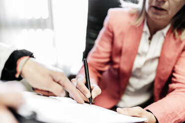 Two businesswomen working on document in office - JRFF01198