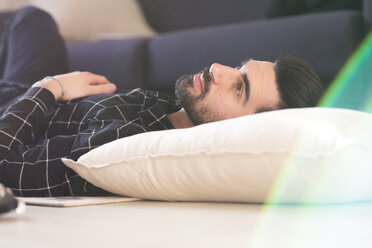 Young man at home lying on couch - FMOF00169