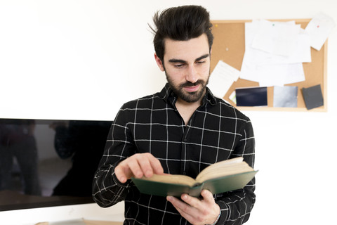 Junger Mann liest Buch, lizenzfreies Stockfoto