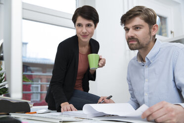 Kollegen arbeiten gemeinsam am Schreibtisch im Büro - FKF02144