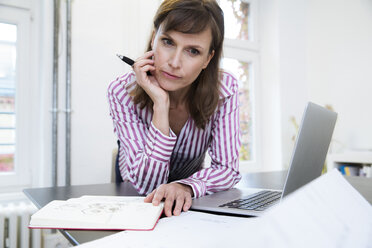 Frau mit Laptop im Büro denkt nach - FKF02178