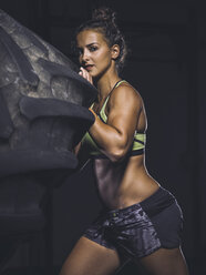 Young woman lifting up a tractor tyre - MADF01324