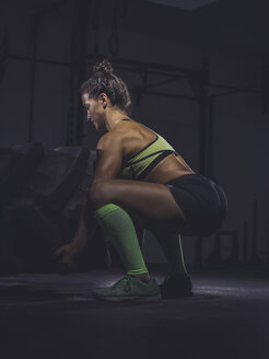 Junge Frau beim Training mit einem Traktorreifen - MADF01326