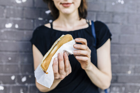 Woman's hand holding Hot Dog, close-up - GIOF01865