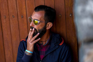Portrait of man wearing mirrored sunglasses smoking cigarillo - SIPF01403