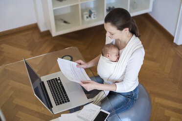 Mutter mit Baby im Tragetuch arbeitet von zu Hause aus - DIGF01514