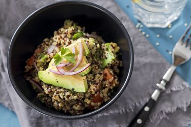 Bowl of Quinoa tricolore with avocado, red onion, tomatoes and flat leaf parsley - YFF00644