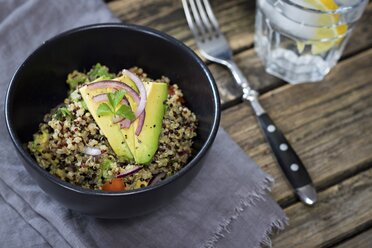 Bowl of Quinoa tricolore with avocado, red onion, tomatoes and flat leaf parsley - YFF00645