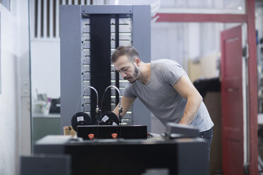 Junger Mann arbeitet in einer Druckerei - SGF02119