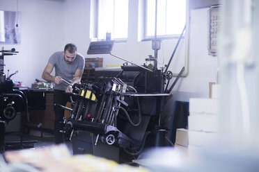 Junger Mann arbeitet in einer Druckerei - SGF02121