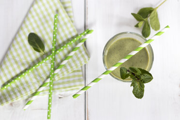 Glass of green smoothie garnished with mint leaves - YFF00646