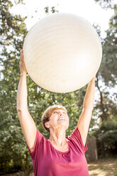 Ältere Frau beim Training mit Fitnessball im Freien - WESTF22672