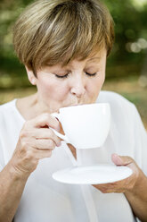Ältere Frau trinkt eine Tasse Kaffee im Freien - WESTF22681