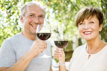 Happy senior couple having glass of red wine outdoors - WESTF22692