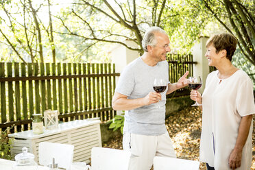 Happy senior couple having glass of red wine outdoors - WESTF22693