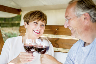Glückliches älteres Paar stößt mit Rotweingläsern an - WESTF22694