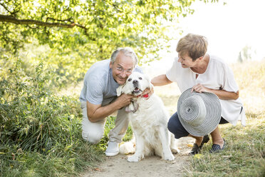 Senior couple petting dog outdoors - WESTF22704