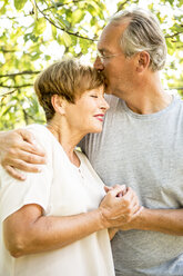 Glückliches älteres Paar umarmt und küsst sich im Freien - WESTF22708