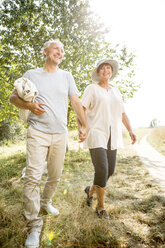 Glückliches älteres Paar beim Spaziergang mit Decke in der Natur - WESTF22726