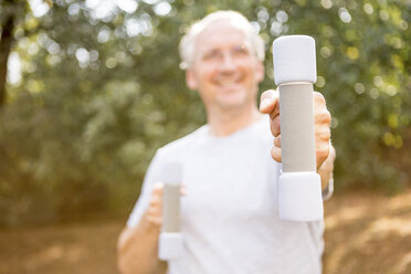 Senior man exercising with dumbbells outdoors - WESTF22765