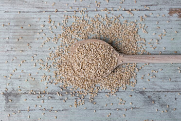 Wooden spoon and sesame seeds on wood - JUNF00833