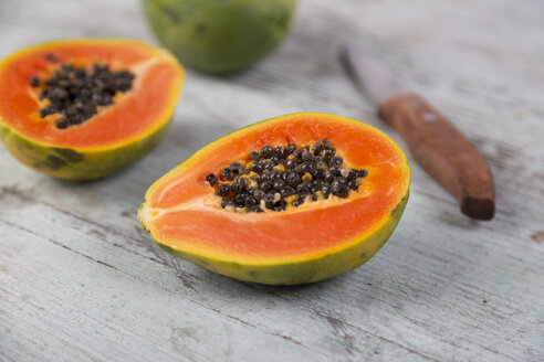 In Scheiben geschnittene Papaya auf Holz - JUNF00839