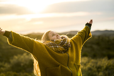 Young woman standing outdoors enjoying the nature - KKAF00426