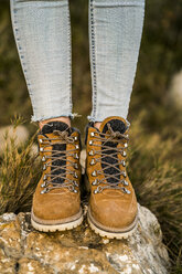 Frau in Wanderschuhen auf einem Felsen stehend - KKAF00431