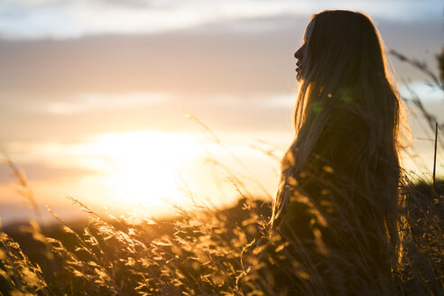 Junge Frau in der Natur bei Sonnenuntergang - KKAF00439